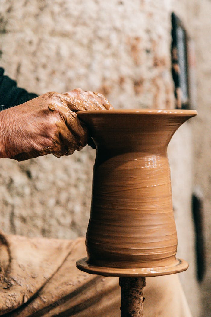 Master artisan shaping clay vase on a pottery wheel, capturing craftsmanship.