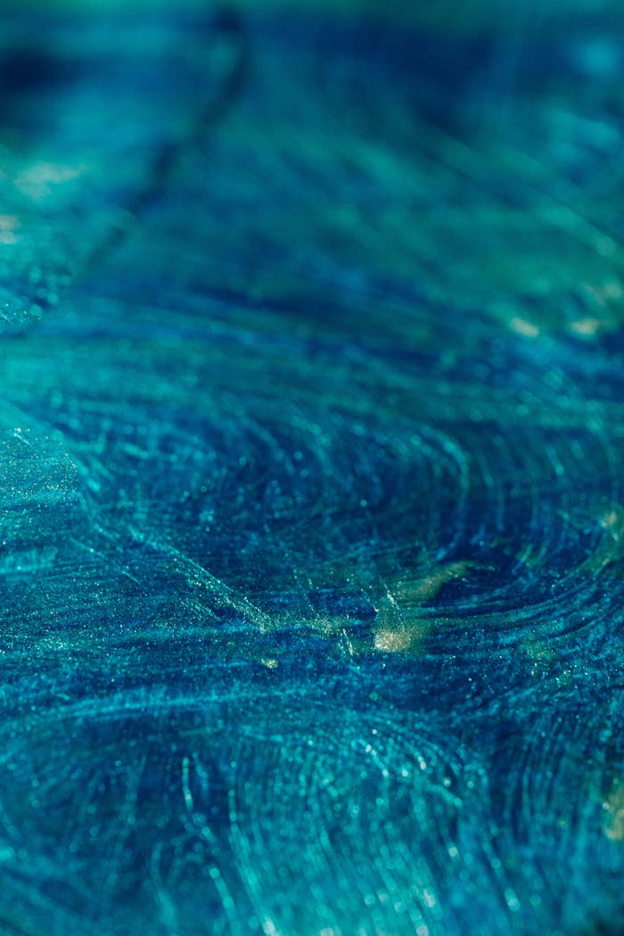 Close-up of a dynamic abstract blue and green swirl pattern, perfect for artistic backgrounds.