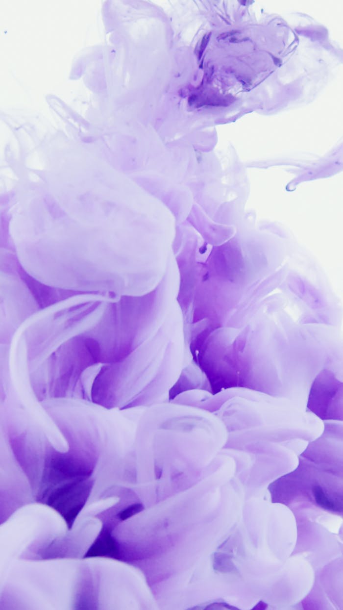 Abstract violet ink swirling in water creates a dreamy, artistic flow.